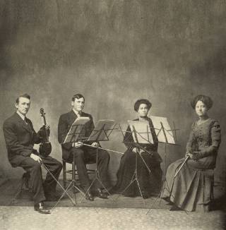 1911 TCU String Quartet Coed Group Four student musicians from 1911 pose for a photo with instruments