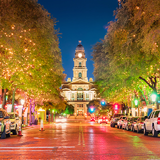 Fort Worth's Main Street near the county courthouse at night Photo: Getty Images A northerly view at night looking up a downtown street lined with trees adorned with sparkling white lights to the county courthouse