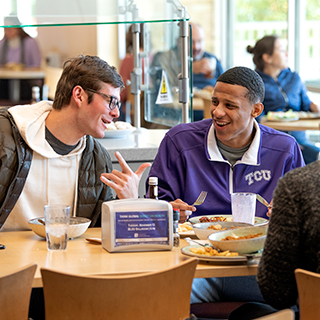 Housing & Dining Two male TCU students share a laugh over lunch at the campus main dining hall