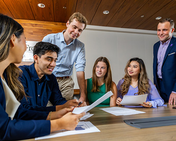Group of students collaborating around a conference table